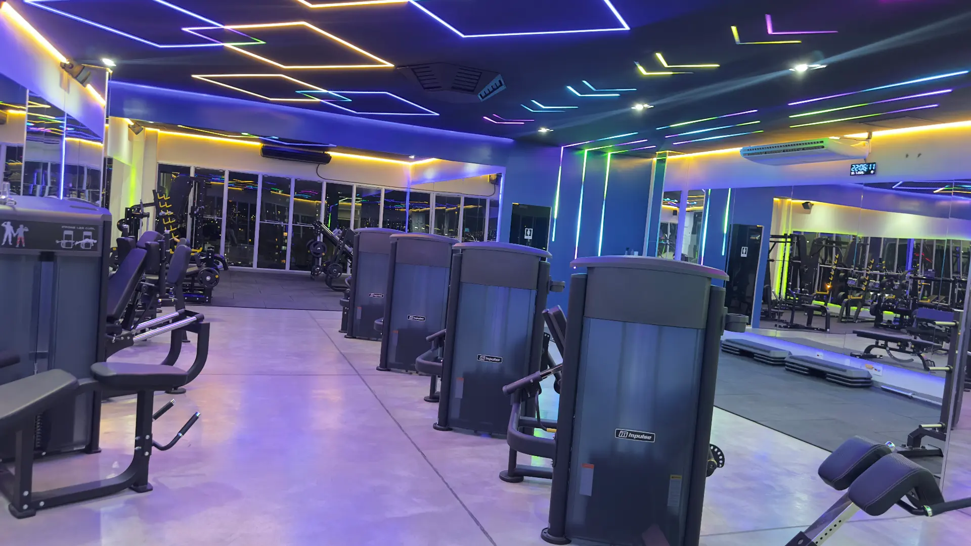 Pavimento com máquinas Impulse enfileiradas, espelhos amplos e janelas com vista noturna de Sorocaba