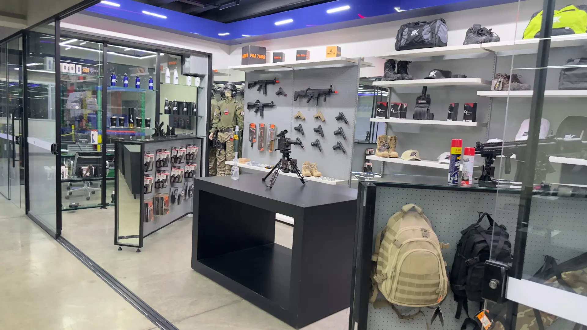 Interior da loja da Sumrak 408 com vitrines, acessórios, calçados, mochilas e artigos táticos expostos